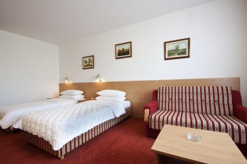 a hotel room with two beds and a couch at Hotel Grand in Sarajevo