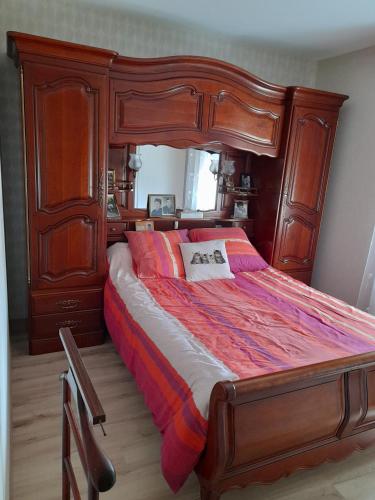 - une chambre avec un grand lit en bois et un cadre en bois dans l'établissement CHEZ VIVIANE, à Celles-sur-Belle