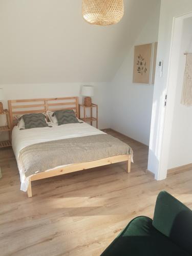 a bedroom with a large bed in a white room at Stodoły Koło Wody Niwka in Niwka