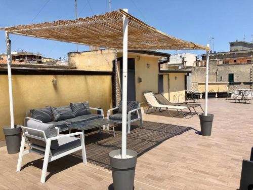 eine Terrasse mit einem Sofa und Stühlen auf dem Dach in der Unterkunft Il Piccolo Albergo Matera in Matera