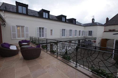 
a patio with a balcony and a large window at Champagne Domaine Sacret - AY in Épernay
