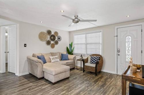 a living room with a couch and a ceiling fan at The Spanish Beach Home only 10mins from the beach! in Largo