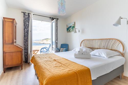 a bedroom with a bed with a view of the ocean at LA MARONAISE - Maison dans la calanque in Marseille