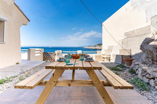 - une table de pique-nique en bois sur une terrasse avec vue sur l'océan dans l'établissement LA MARONAISE - Maison dans la calanque, à Marseille