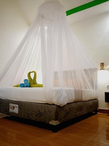 a bed with a mosquito net on top of it at Yayan Bungalow in Gili Islands