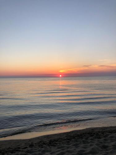 a sunset over the ocean with a sandy beach at Sunnyside Villa in Durrës
