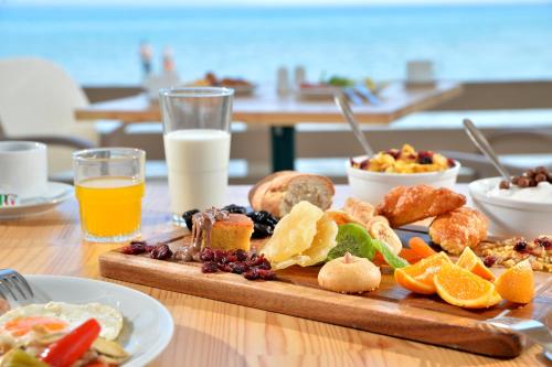 a table with a tray of breakfast foods and orange juice at Alykanas Beach Grand Hotel by Zante Plaza in Alikanas