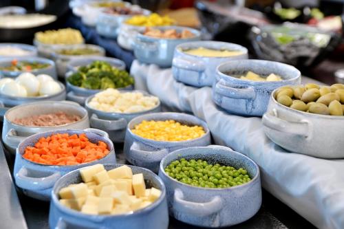 a row of blue bowls filled with different types of food at Alykanas Beach Grand Hotel by Zante Plaza in Alikanas