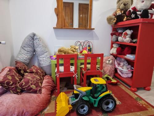 a room with two red chairs and stuffed animals at Duna-Beach Apartman in Kimle