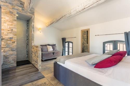 una camera da letto con un letto con cuscini rossi di Nuit Etoilée a LʼIsle-sur-la-Sorgue
