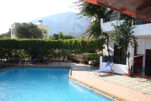 a swimming pool in front of a house with a mountain at Hotel Mary in Marathokampos