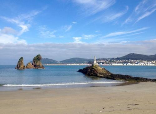 einen Strand mit einigen Felsen im Wasser in der Unterkunft Viveiro Centro Histórico in Viveiro