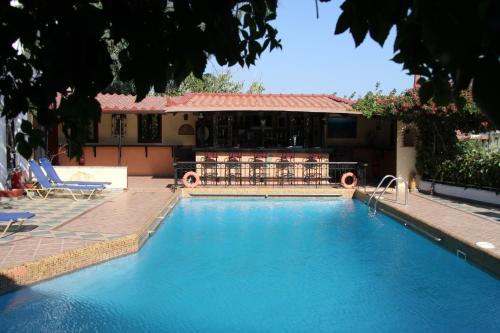 a swimming pool in front of a house at Hotel Mary in Marathokampos