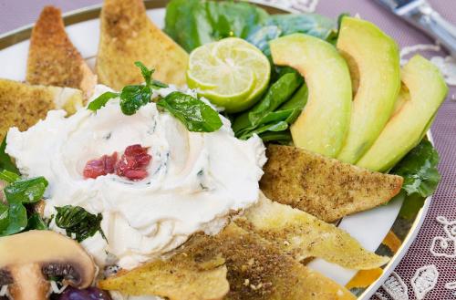 a plate of food with a salad with dip and vegetables at San Giovanni Stanly Hotel in Alexandria
