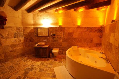 a bathroom with a tub and a toilet and a sink at Avanos Suites in Avanos