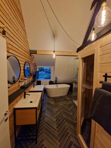 een grote badkamer met een bad en een wastafel bij Ferienwohnung Auszeit in Weeze