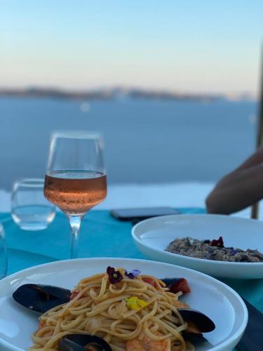 a table with two plates of pasta and a glass of wine at Filotera Suites in Oia