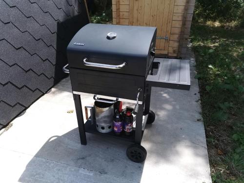 a charcoal grill with drinks on a cart on a sidewalk at Charmant POD en bois près d'un plan d'eau in Nielles-lès-Ardres