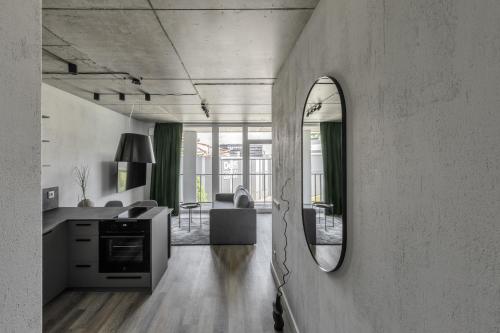 a living room with a mirror and a kitchen at Urban Jungle Apartments by Reside Baltic in Vilnius