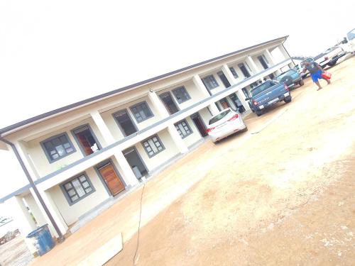a large white building with cars parked in a parking lot at BF Dlamini Guest House in Amanzimtoti