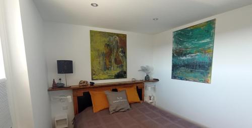 ein Schlafzimmer mit einem Bett mit zwei Gemälden an der Wand in der Unterkunft Haus Brandenburg App 43 in Westerland