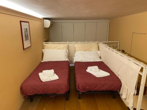 a small room with two beds with towels on them at LA PIGNA in Rome