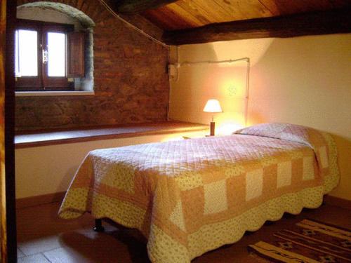 a bedroom with a bed with a lamp and a window at Locanda Dei Cocomeri in Montalto Uffugo