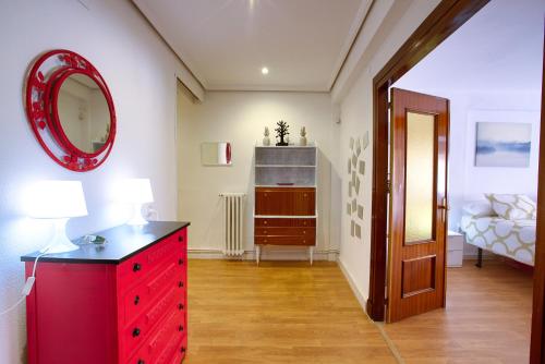 - une commode rouge dans une pièce avec un miroir rouge dans l'établissement CUENCALOFT RAMÓN Y CAJAL 18, à Cuenca