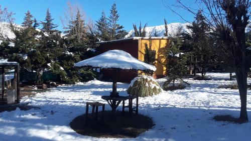 a snow covered yard with a table and chairs in the snow at POSADA MI ESPERANZA in Cacheuta
