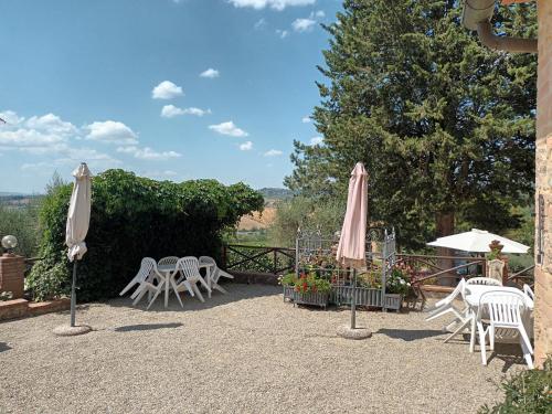 a patio with tables and chairs and umbrellas at Poggio Massiccioli in Poggibonsi