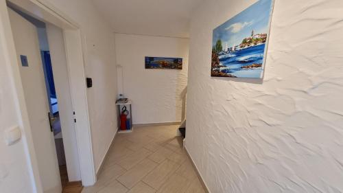 a hallway with two paintings on a white wall at Apartments Kivi in Novigrad Istria