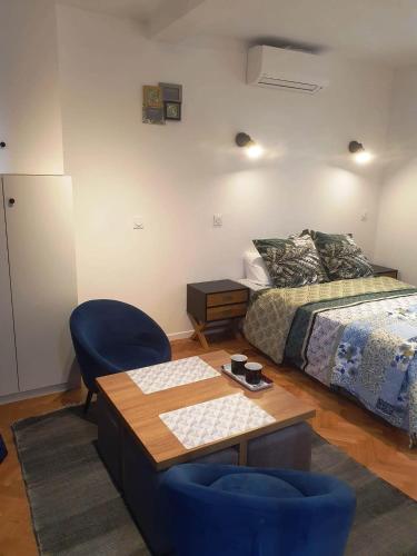 ein Schlafzimmer mit einem Bett und einem blauen Stuhl in der Unterkunft Luxe studio près de CDG & Paris& Parc d'exposition in Aulnay-sous-Bois