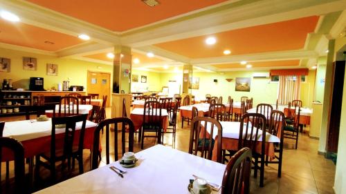 Hotel Baixamar في سانكسينكسو: غرفة طعام مع طاولات وكراسي في مطعم