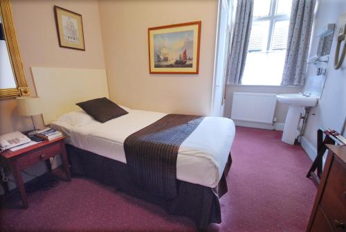 a hotel room with a bed and a window at Tree Hotel at Iffley in Oxford