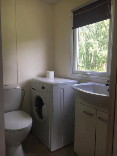 uma casa de banho com uma máquina de lavar roupa e um lavatório em Holender nad Saskiem em Kobyłocha