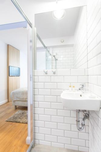a white bathroom with a sink and a shower at Smart Hotel in Gdańsk