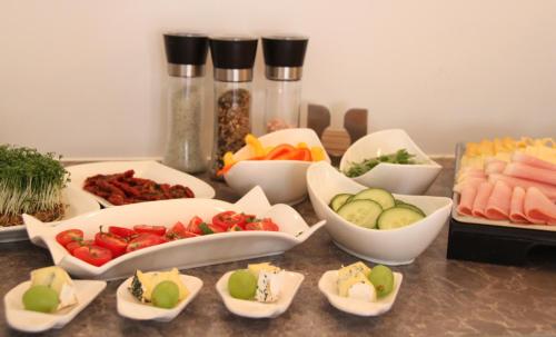 a table topped with bowls of different types of vegetables at Gästehaus Lokalaugenschein in Podersdorf am See