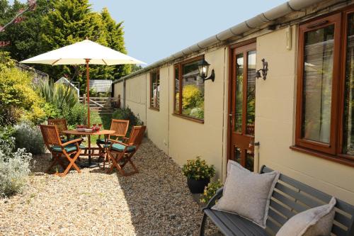 a patio with a table and chairs and an umbrella at Great Western Lodge at Eaton Manor in Eaton