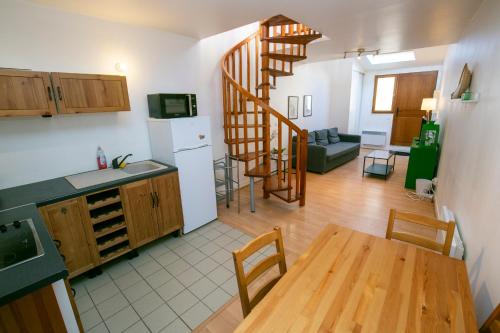 a kitchen and a living room with a table and a staircase at Relais du 21 in Saint-Germain-en-Laye