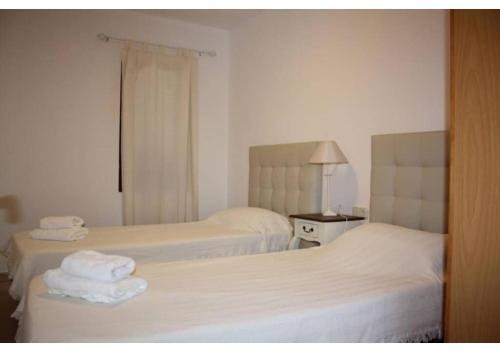 two beds in a hotel room with towels on them at Anahi Homes Corralejo - Villa Drago 12 in La Oliva