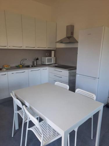 a white kitchen with a white table and chairs at Dolce Relax - Calabria in Catanzaro