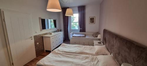 um quarto com uma cama, uma cómoda e uma janela em Apartma Zlati konzul em Koper