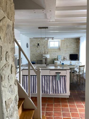 - une cuisine et un salon avec un comptoir et une table dans l'établissement La Maison Bleue, à Port-en-Bessin-Huppain