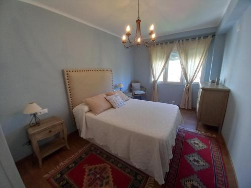 リベイラにあるPrecioso apartamento a 1 minuto de la playaの白いベッドと窓のある寝室