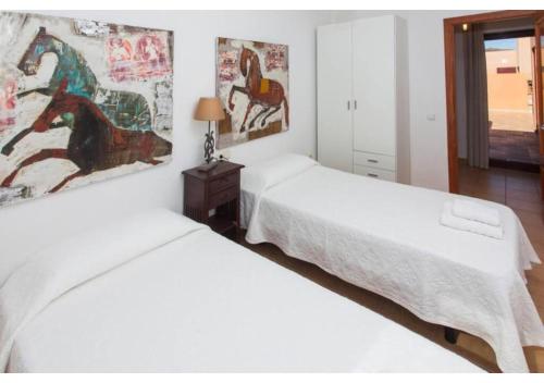 2 bedden in een slaapkamer met witte lakens bij Anahi Homes Corralejo - Villa Dracaena 2 in La Oliva