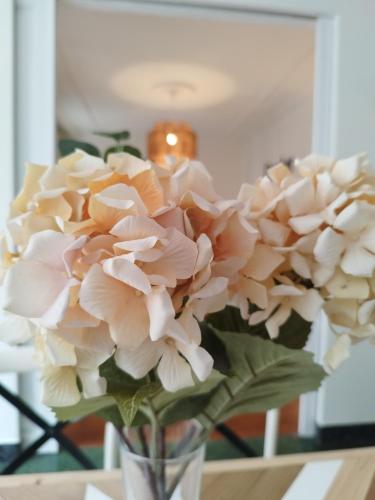 a vase filled with pink flowers on a table at Railway by Staynnapartments in Bilbao
