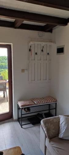 a living room with a bench in a room with a window at Mrežnica - Zelena oaza II in Generalski Stol