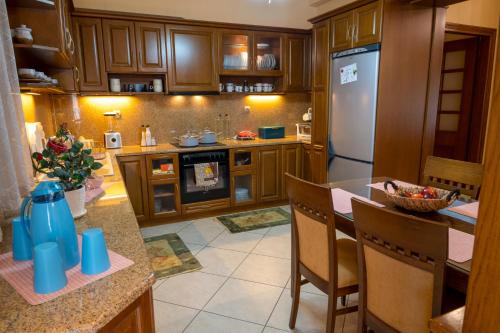 a kitchen with wooden cabinets and a refrigerator at Sevi's Luxury Guesthouse Villa in Ioannina