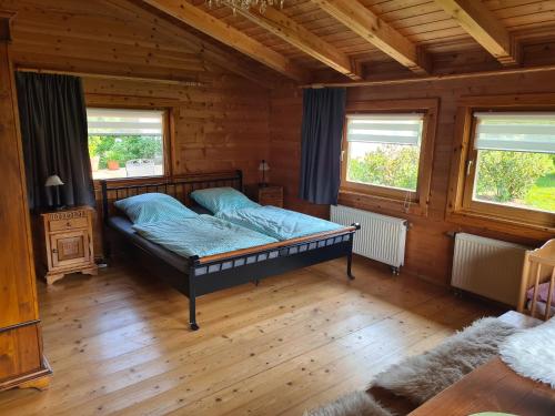 - une chambre avec un lit dans une pièce en bois dans l'établissement Holzkastl, à Eging am See