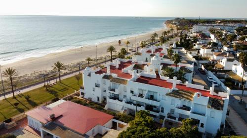 una vista aérea de una playa con casas blancas en Apartamento a pie de playa La Barrosa en Chiclana de la Frontera